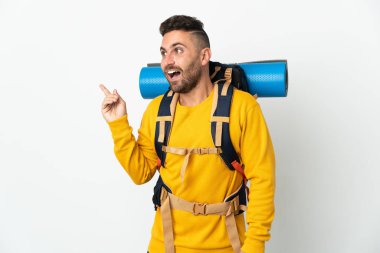 İzole edilmiş arka planda büyük bir sırt çantası olan genç dağcı parmağını kaldırarak çözümü bulmaya çalışıyor.