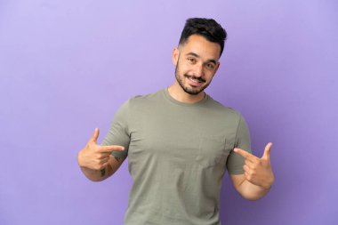 Mor arka planda soyutlanmış, gururlu ve kendini beğenmiş genç beyaz bir adam.