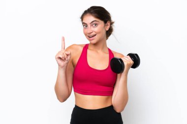 Beyaz arka planda izole haldeki beyaz kadın halter kaldırıyor ve en iyinin işareti olarak parmağını kaldırıyor.