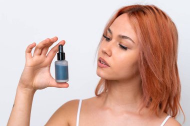 Beyaz arka planda izole edilmiş genç bir Rus kız elinde bir serum tutuyor. Portreyi kapat