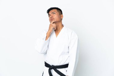 Beyaz arka planda karate yapan genç Ekvadorlu adamın şüpheleri var.