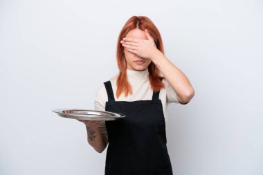 Tepsisi beyaz arka planda izole edilmiş genç Rus garson gözlerini elleriyle kapatıyor. Bir şey görmek istemiyorum.
