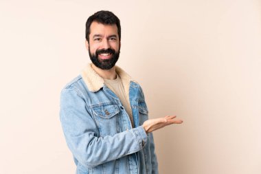 İzole edilmiş arka planda sakallı beyaz bir adam gülümserken bir fikir sunuyor.