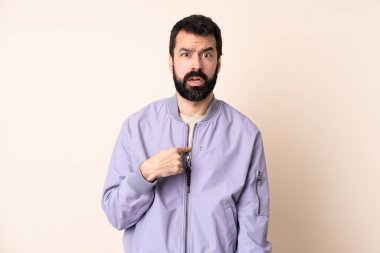Sakallı, ceketli, soyutlanmış bir geçmişi olan beyaz bir adam kendini işaret ediyor.