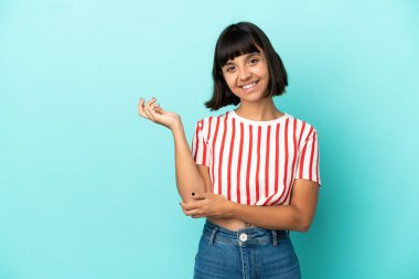 Mavi arka planda soyutlanmış genç bir ırk kadını davet etmek için ellerini yana uzatıyor.