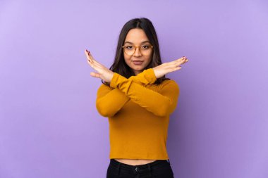 Mor arka planda izole edilmiş genç melez kadın jest yapmıyor.