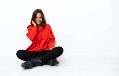 Yerde patenleriyle gülüp duran Asyalı genç bir kadın.