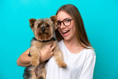 Mavi arka planda köpeği tutan Litvanyalı genç bir kadın.