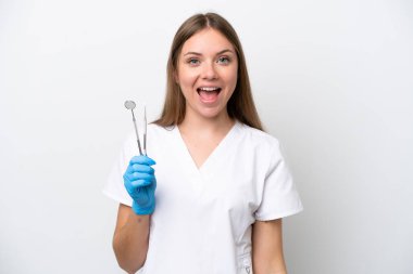 Dişçi kadın beyaz arka planda şaşırtıcı yüz ifadesiyle izole araçlar tutuyor.