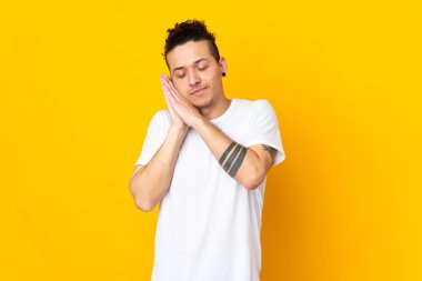 İzole edilmiş arka plan üzerinde beyaz bir adam uyku jesti yapıyor.