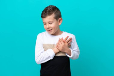 Küçük çocuk mavi arka planda izole edilmiş, kalbinde ağrı var.