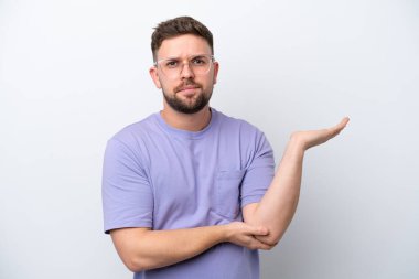 Beyaz arka planda soyutlanmış genç beyaz bir adamın şüpheleri var.