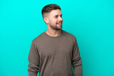 Genç beyaz adam mavi arka planda izole edilmiş.