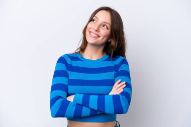 Beyaz arka planda izole edilmiş genç beyaz kadın gülümserken yukarı bakıyor.