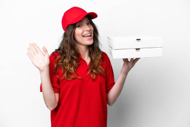 Pizza dağıtan kadın iş üniformalı beyaz arka planda izole pizza kutuları alıyor mutlu bir ifadeyle selamlıyor.