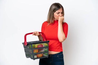 Genç Romen kadın elinde yiyecek dolu bir sepet tutuyor. Beyaz arka planda izole edilmiş, kuşkuları var.