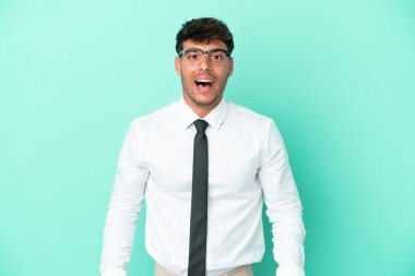 Beyaz iş adamı, mavi arka planda yalıtılmış, sürpriz bir yüz ifadesi var.