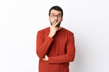 Sakallı, beyaz arka planı olan beyaz, yakışıklı bir adam sağa bakarken şaşırmış ve şok olmuştu.