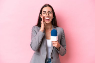 Kafkasyalı genç sunucu kadın pembe arka planda izole edilmiş, şaşırmış ve şok olmuş bir yüz ifadesi var.