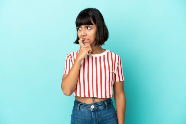 Genç melez kadın mavi arka planda izole edilmiş gergin ve korkmuş.