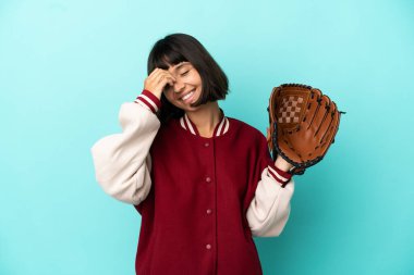 Beyzbol eldivenli, genç, melez bir kadın. Mavi arka planda izole edilmiş, gülümsüyor.