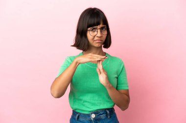 Pembe arka planda izole edilmiş genç melez bir kadın.