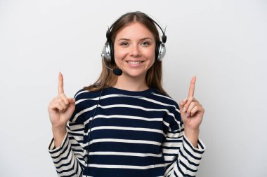 Beyaz arka planda izole edilmiş bir kulaklıkla çalışan beyaz pazarlamacı kadın harika bir fikre işaret ediyor.