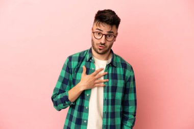 Pembe arka planda izole edilmiş genç beyaz adam kendini işaret ediyor.