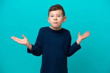 Küçük çocuk mavi arka planda izole edilmiş şüpheli hareketler yapıyor.