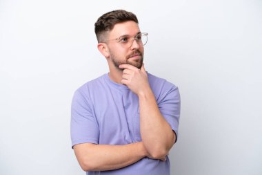 Beyaz arka planda izole edilmiş genç beyaz adam yukarı bakarken bir fikir düşünüyor.