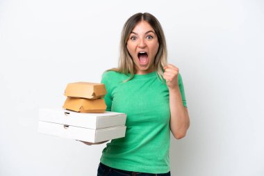 Genç Romen kadın elinde fast-food tutarak beyaz arka planda zaferi kutluyor.