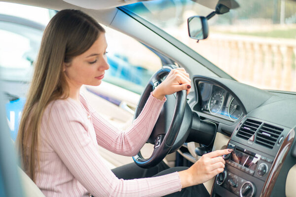 Young pretty blonde woman inside a car