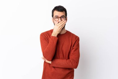 Beyaz tenli, sakallı, beyaz arka planda elleri ve ağzı kapalı beyaz bir adam.