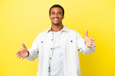 Sarı arka planda Afro-Amerikalı yakışıklı adam sunar ve davet eder.