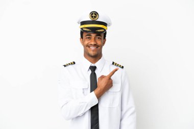 İzole edilmiş beyaz arka plan üzerinde Afrikalı Amerikan Uçak Pilotu bir ürünü sunmak için kenarı işaret ediyor