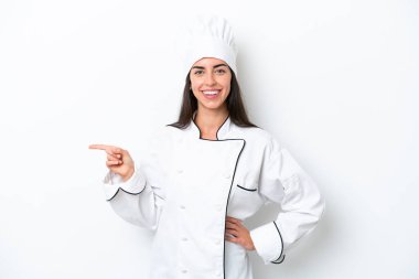 Beyaz arka planda genç aşçı kadın işaret ediyor.
