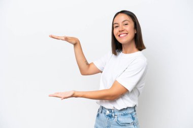 Beyaz arka planda izole edilmiş genç beyaz bir kadın ilan vermek için kopyalama alanı tutuyor.