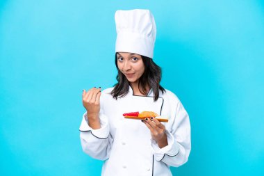 Mavi arka planda saşimi tutan genç İspanyol aşçı kadın bizimle gelmesi için davet ediyor. Gelmene sevindim.