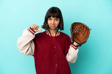 Beyzbol eldivenli, mavi arka planda soyutlanmış, negatif ifadeli, genç, melez bir kadın.