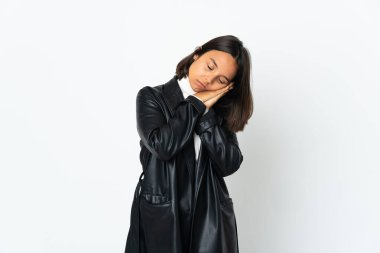 Beyaz arka planda izole edilmiş genç Latin bir kadın uyku jesti yapıyor.