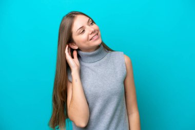 Genç Litvanyalı kadın mavi arka planda izole edilmiş bir fikir düşünüyor.