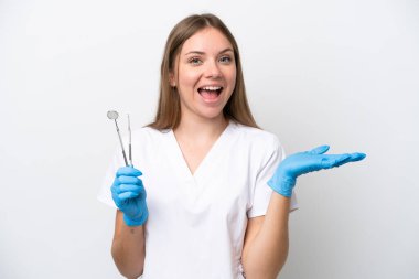 Dişçi kadın beyaz arka planda şok olmuş yüz ifadesi ile izole araçlar tutuyor