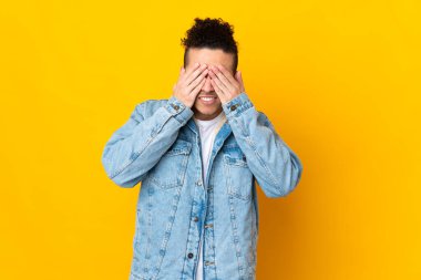 İzole edilmiş arka planda beyaz bir adam elleriyle gözlerini kapatıyor.