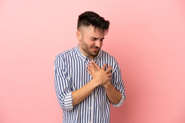 Pembe arka planda izole edilmiş beyaz bir adam. Kalbinde bir ağrı var.