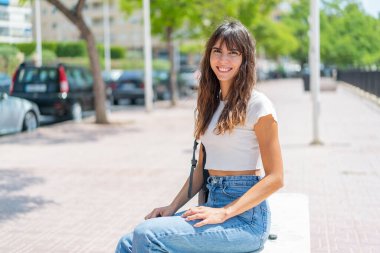 Açık havada genç bir kadın Neşeli bir ifadeyle