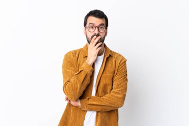 Beyaz arka planda kadife ceket giyen, sakallı, beyaz saçlı yakışıklı bir adam sağa bakarken şaşırmış ve şok olmuştu.