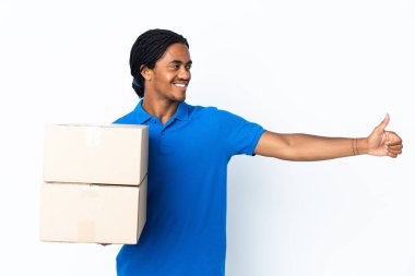 Beyaz arka planda örülü Afro-Amerikan bir adam baş parmak hareketi yapıyor.