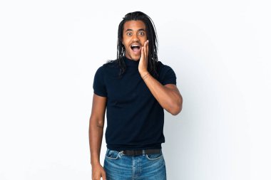 Beyaz arka planda örgü ören, şaşırmış ve şok olmuş yüzü olan Afro-Amerikan bir adam.