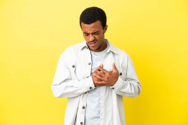 Sarı arka planda yaşayan Afro-Amerikalı yakışıklı bir adam. Kalbinde bir ağrı var.