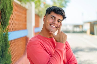 Açık havada gülümseyen genç bir İspanyol.